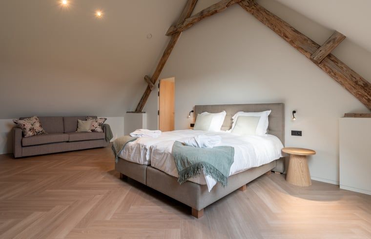 Cozy bedroom in Holiday Home in Kasterlee, Antwerp, Belgium, with rustic wooden beams and comfortable double bed.