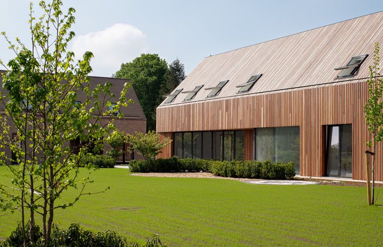 Ferienhaus in Kasterlee, modernes Ferienhaus in der gruenen Umgebung von Antwerpen, Belgien, mit grossem Garten und Holzfassade.