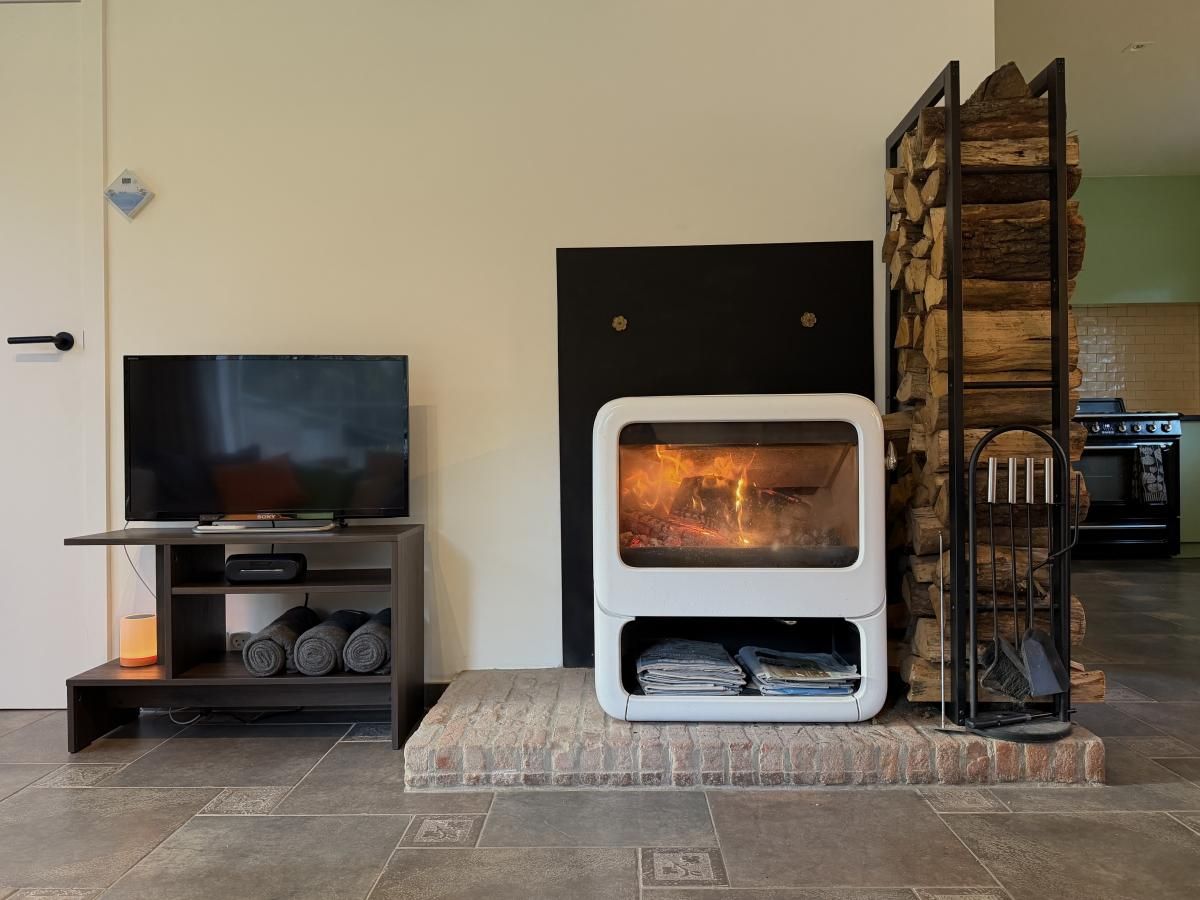 Cozy dining room in Lierelodge vacation home, Oud-Turnhout, Belgium, with wooden furniture and views of the wooded area.