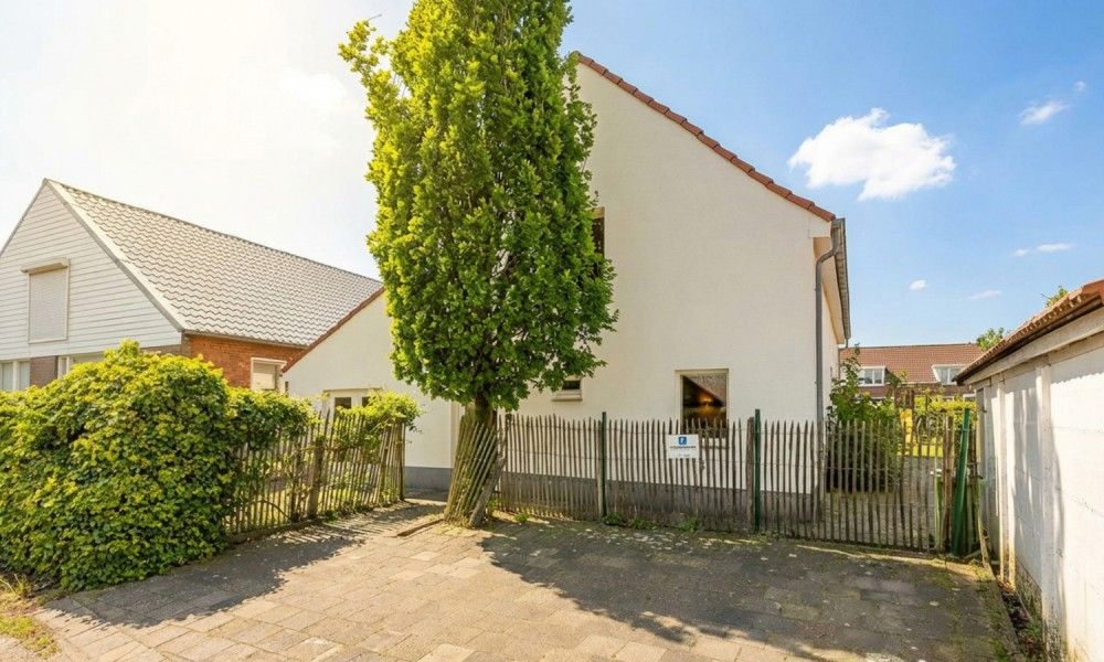 De Morgenstond vakantiehuis in Baarle-Hertog, Antwerpen, biedt een charmante buitenkant met groene omgeving en zonnige hemel.