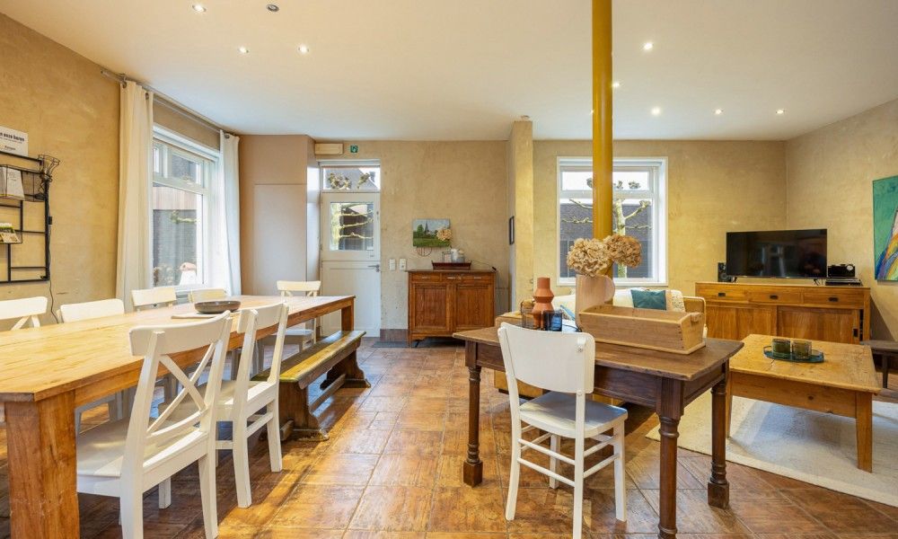 Gezellige woonkamer van vakantiehuis De Morgenstond in Baarle-Hertog, Antwerpen, met een ruime eettafel en comfortabele zithoek.
