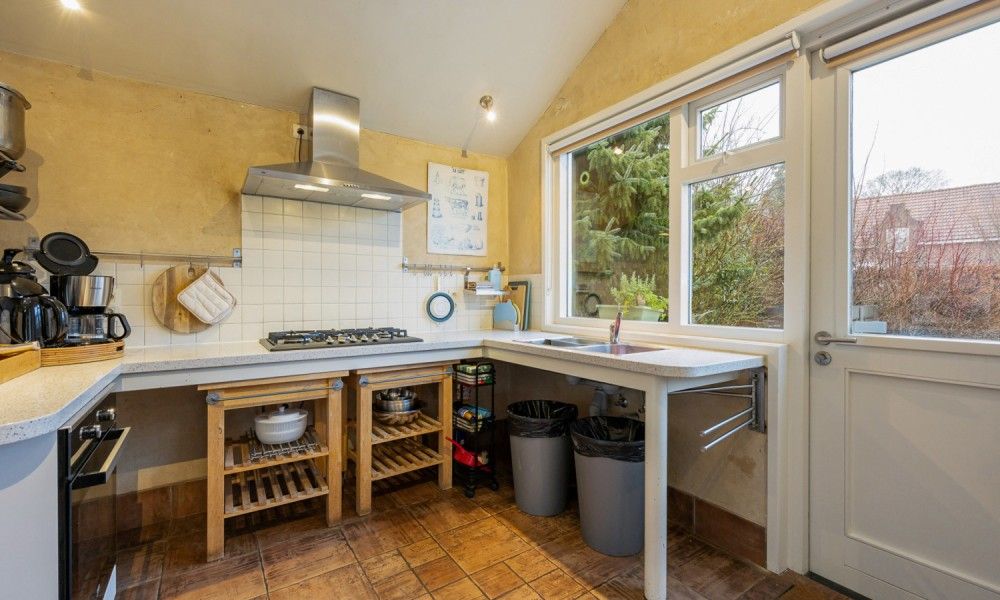 Moderne keuken in vakantiehuis De Morgenstond, Baarle-Hertog, Antwerpen met ruime werkbladen en uitzicht op groene omgeving.