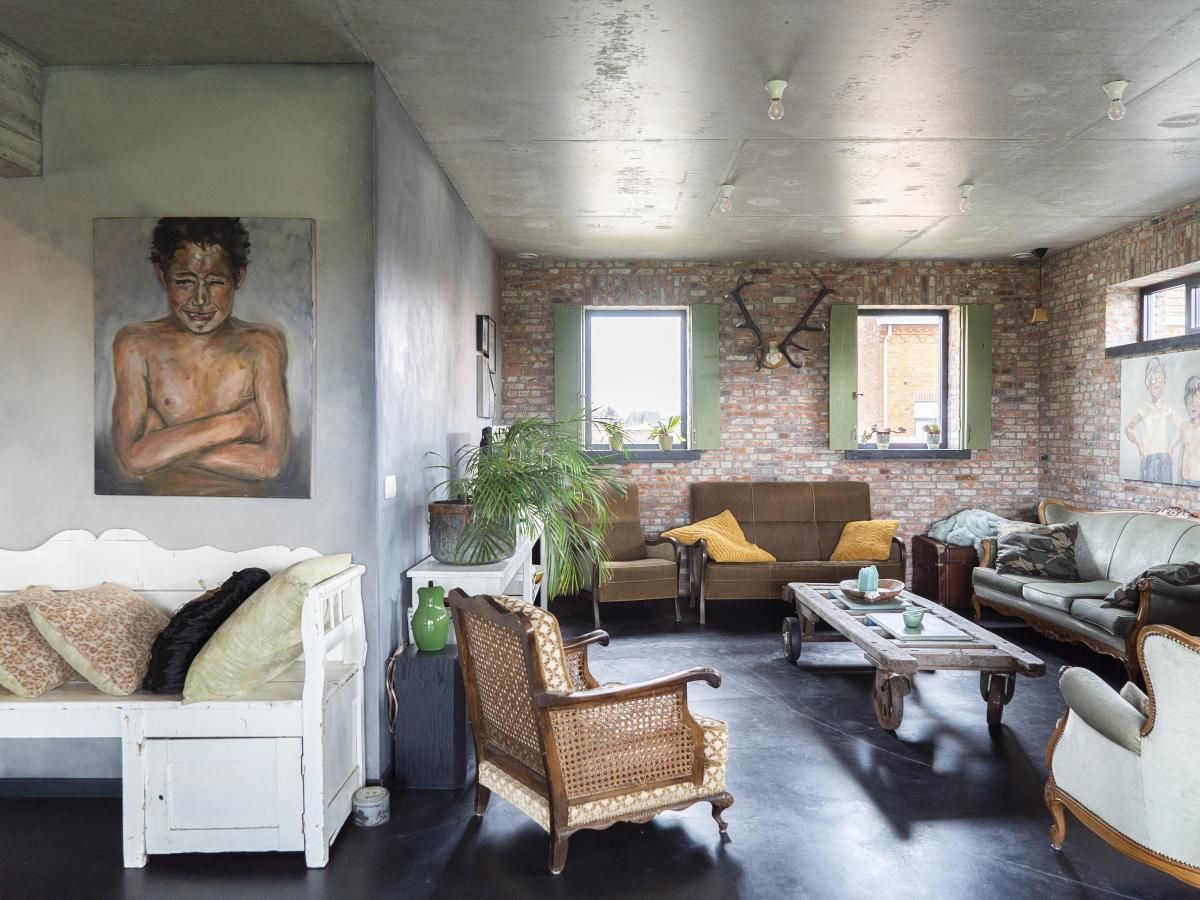 Gezellige woonkamer van vakantiehuis De Lieshoeve in Arendonk, Antwerpen, met vintage meubels en kunst aan de muur.