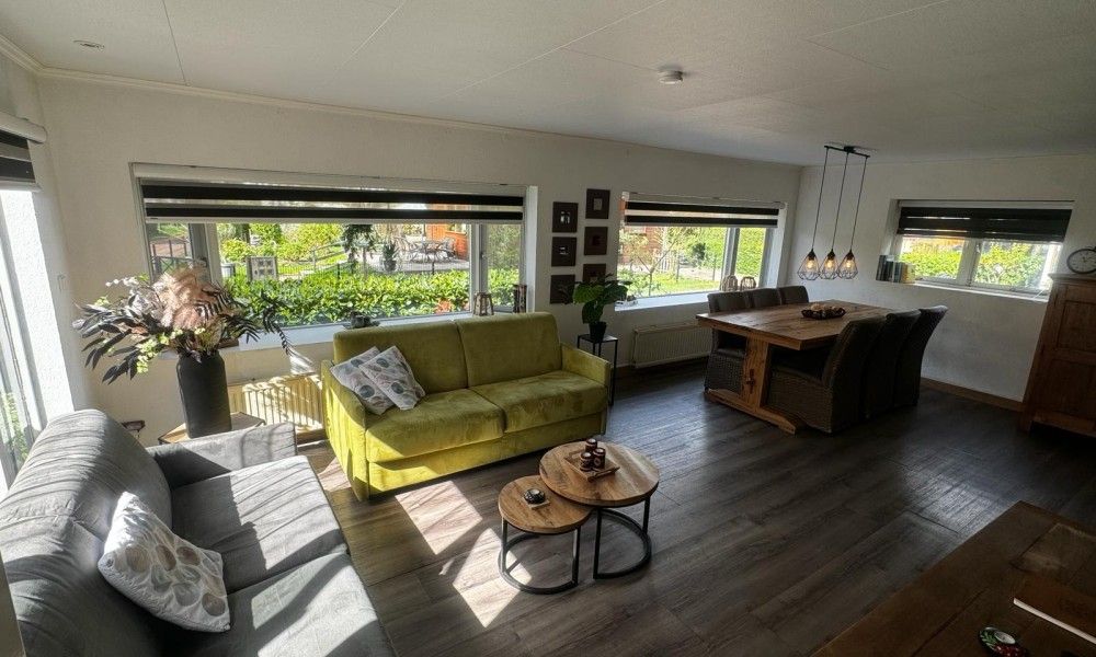 Helles Wohnzimmer des Chalet Sigal in Poppel, Antwerpen. Gemuetliche Einrichtung mit Blick auf die gruene Umgebung.