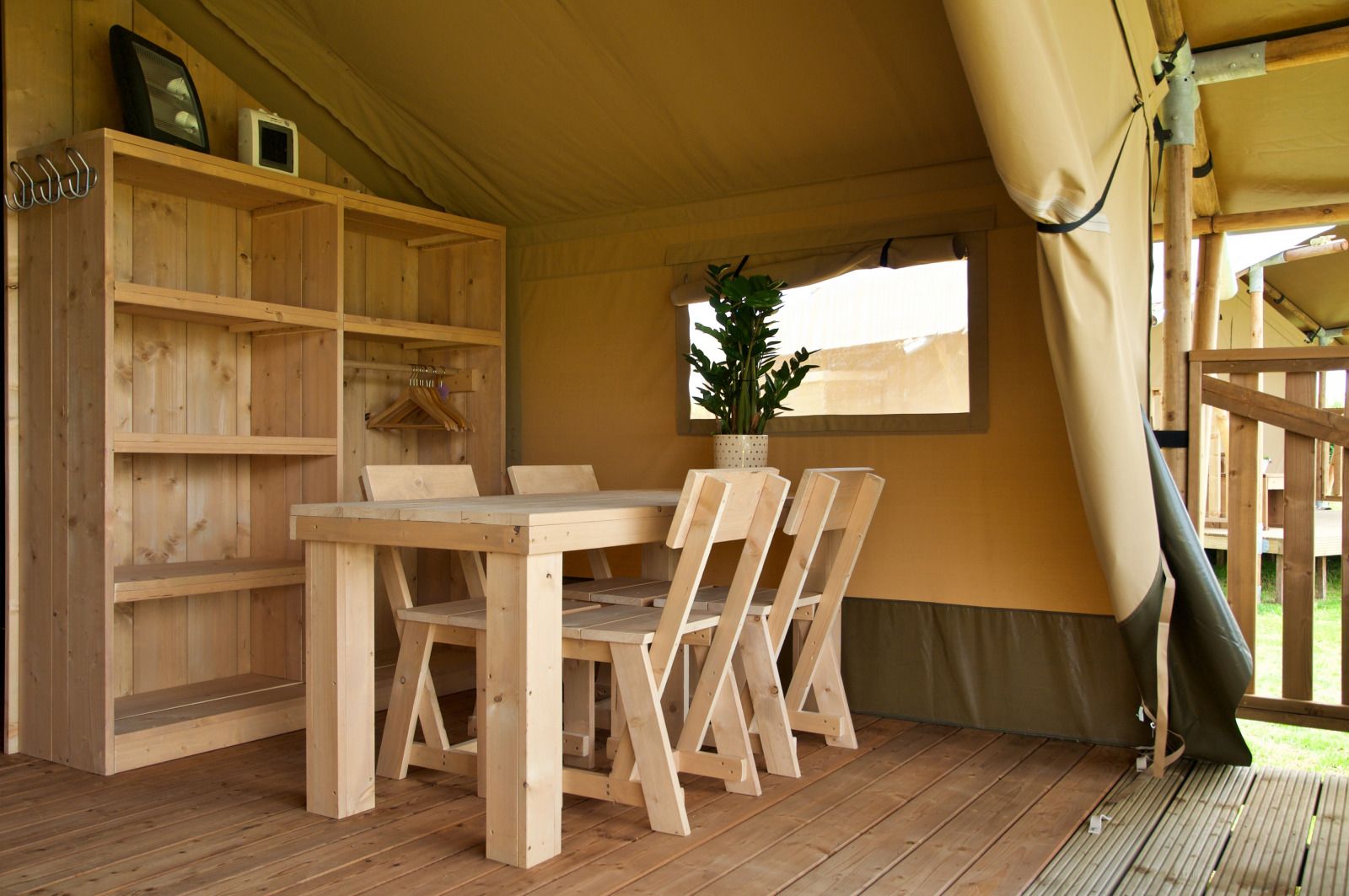 Cozy interior of Safari tent incl. sanitary facilities in Lichtaart, Antwerp. Glamping lodge with wooden furniture and natural atmosphere.