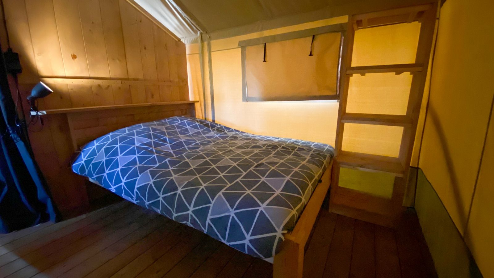 Cozy bedroom in Safari tent incl. sanitary facilities, located in Lichtaart, Antwerp, Belgium. Experience luxury glamping in a comfortable tent.