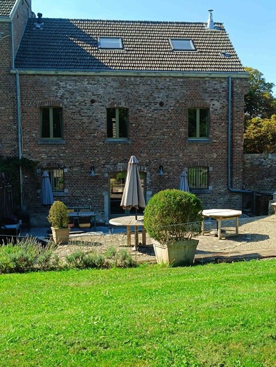 Gemael1744 vakantiehuis in Voeren, Limburg, Belgie met charmante bakstenen gevel en uitnodigend terras in een groene omgeving.