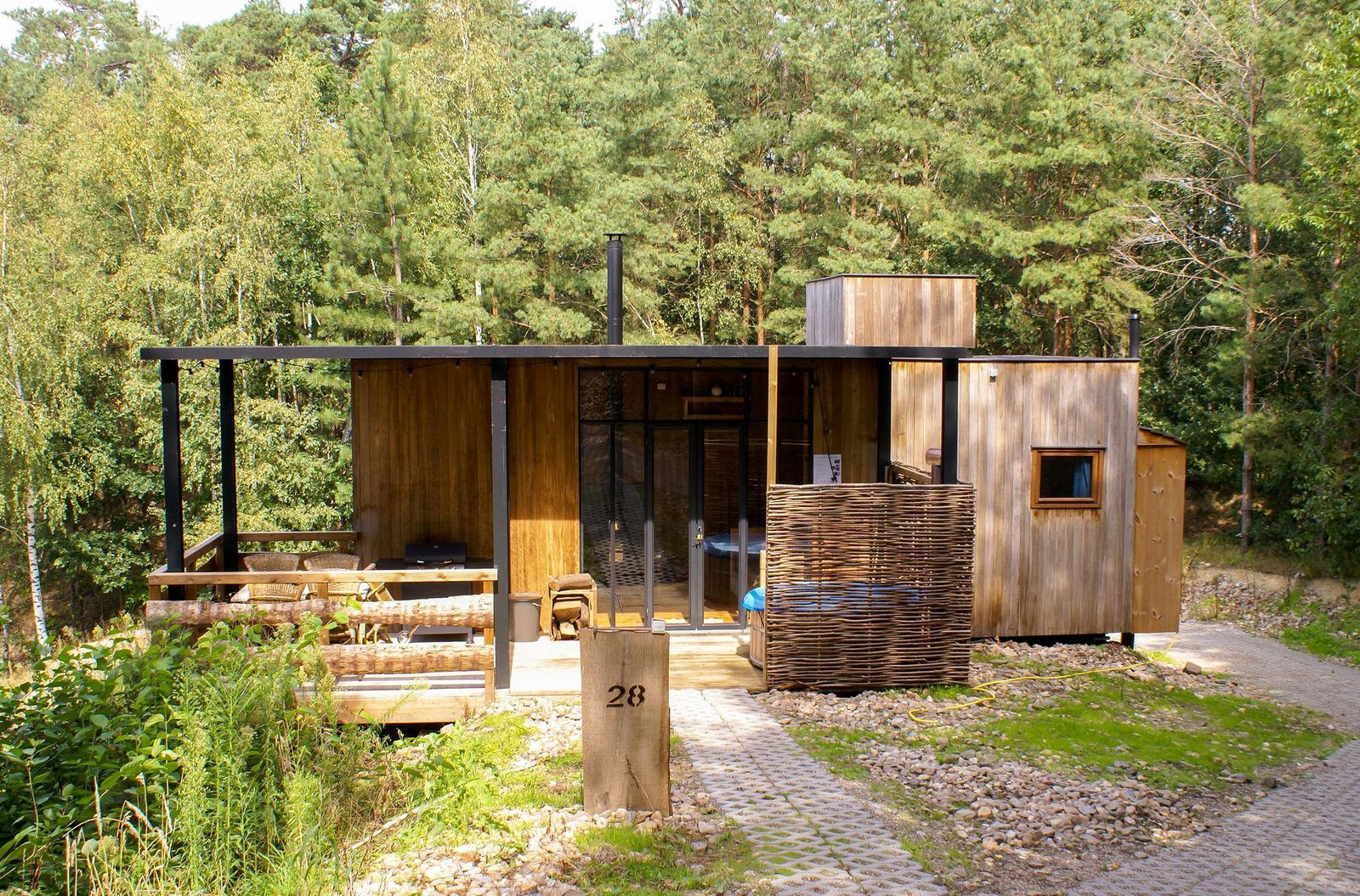 Watercabin met hottub in Neeroeteren, Limburg, Belgie, biedt een rustieke glamping ervaring te midden van weelderige natuur en bosrijke omgeving.