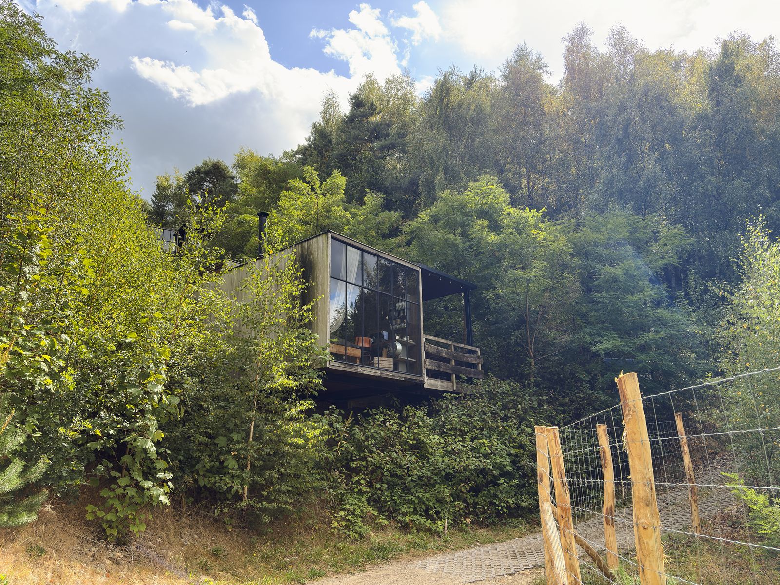 Watercabin met hottub in Neeroeteren, Limburg, Belgie, omgeven door weelderige natuur, ideaal voor een rustgevend verblijf in een vakantiehuis.