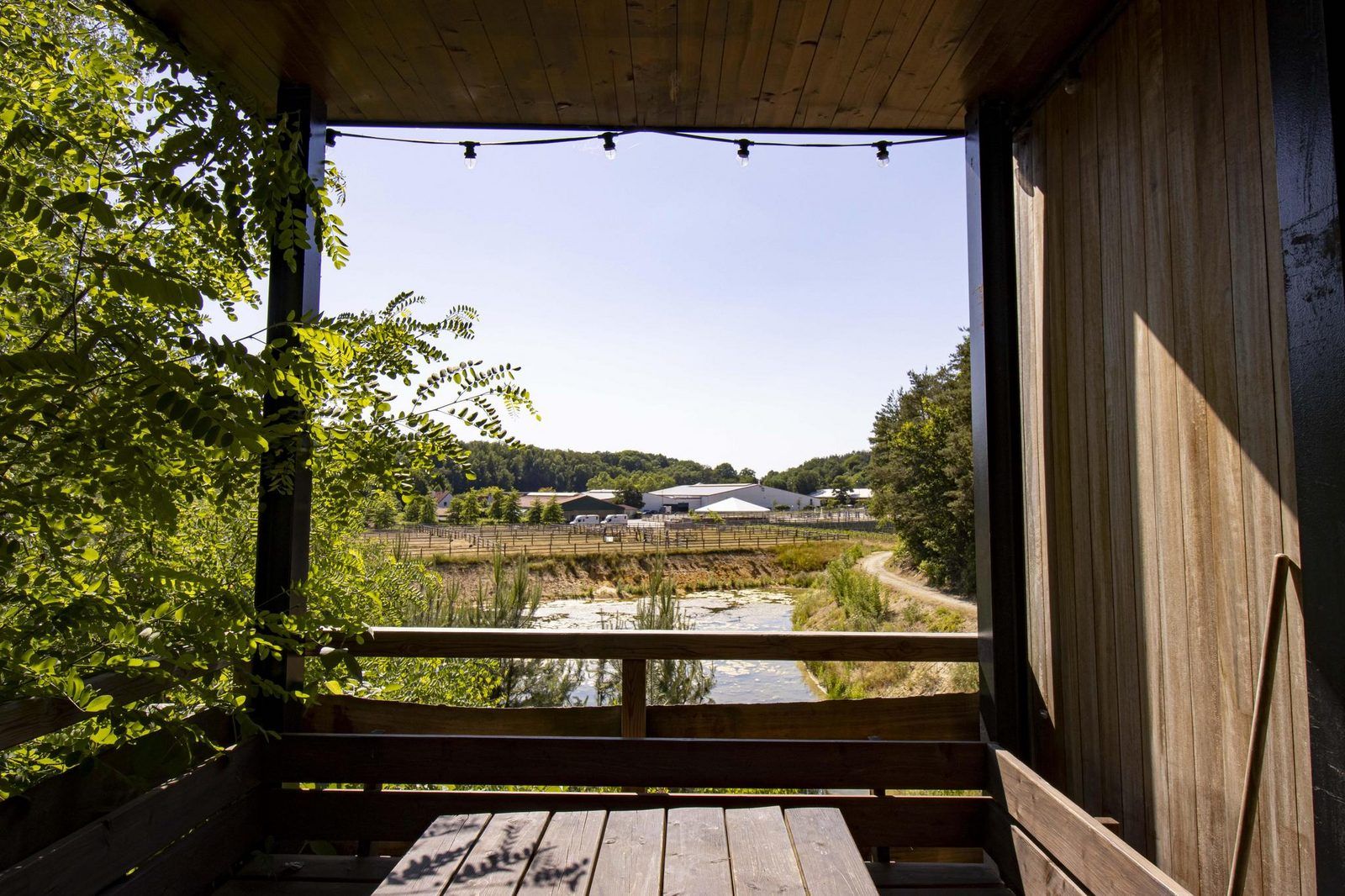 Geniet van het uitzicht vanaf de veranda van de Watercabin met hottub in Neeroeteren, Limburg, Belgie, omgeven door prachtige natuur.