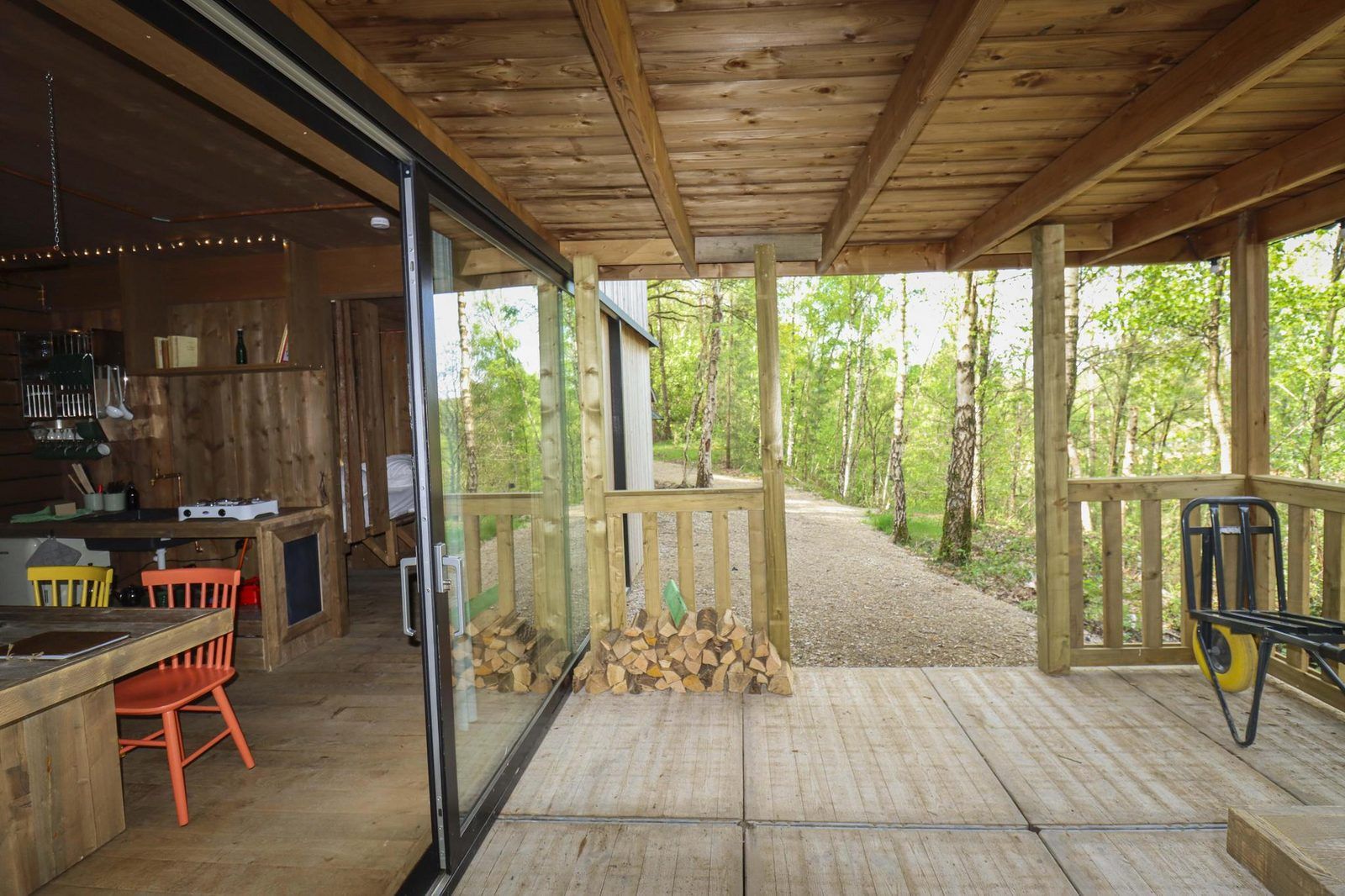 Binnenruimte van Comfort Classic vakantiehuis in Neeroeteren, Limburg, Belgie, met uitzicht op veranda en omliggende bossen.