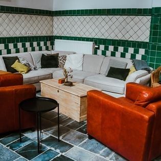 Gezellige zithoek in FreLune, Tongeren, met comfortabele banken en warme kleuren voor een ontspannen verblijf.