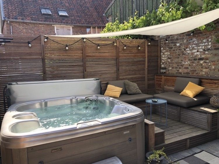 Luxe jacuzzi en loungehoek in FreLune, Tongeren, perfect voor ontspanning en comfort in de buitenlucht.