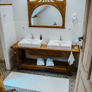 Stijlvolle badkamer in FreLune vakantiehuis, Tongeren, met dubbele wastafel en houten details voor een luxe ervaring.
