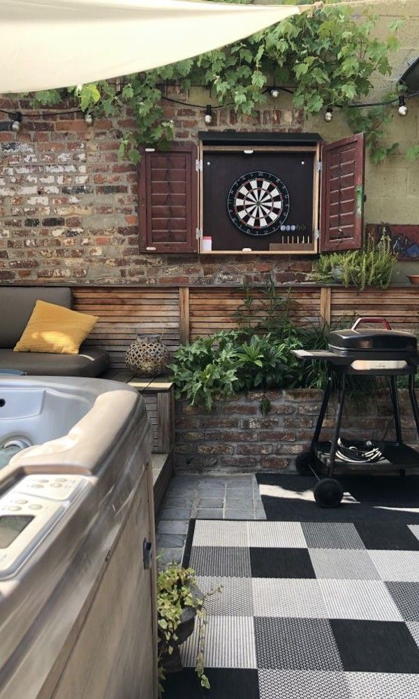 Buitenruimte van FreLune, Tongeren, met dartbord en jacuzzi, ideaal voor ontspanning en spelplezier.