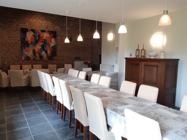 Gezellige eetkamer in vakantiehuis Servaeshoeve - Gerstebaard, Borgloon, Limburg, Belgie, met lange tafel en sfeervolle verlichting.