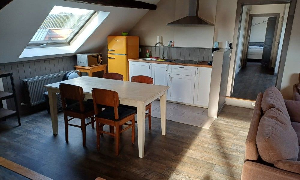Gezellige keuken in Aan Maas & Grens vakantiehuis in Kinrooi, Limburg, Belgie, met houten tafel en retro koelkast.
