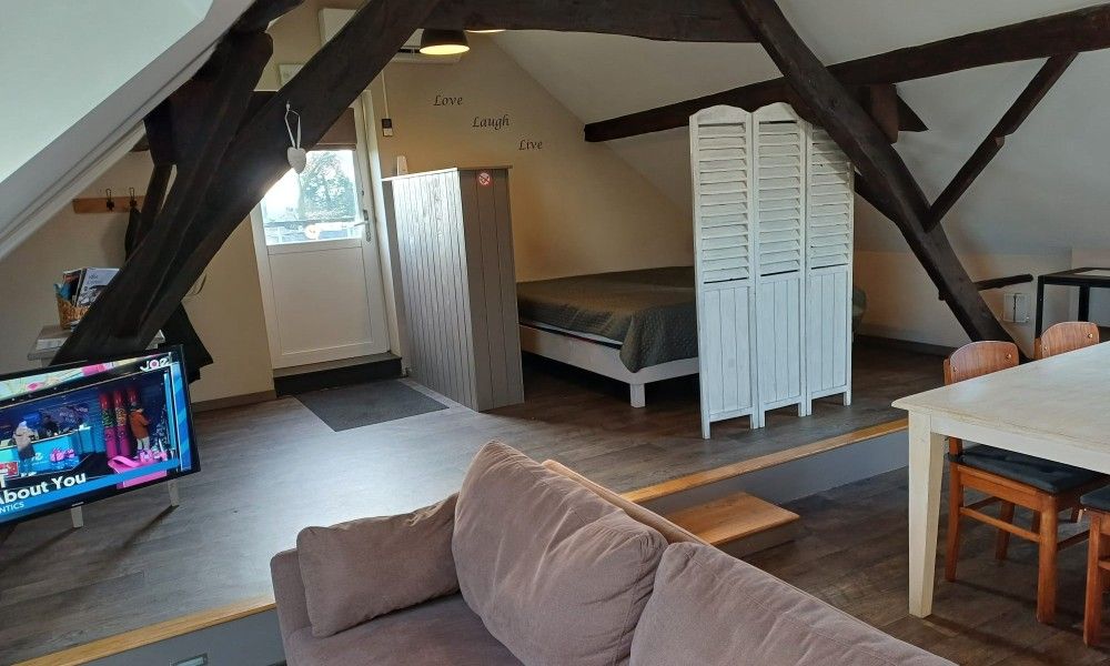 Open leefruimte met zicht op slaapkamer in Aan Maas & Grens vakantiehuis in Kinrooi, Limburg, Belgie.