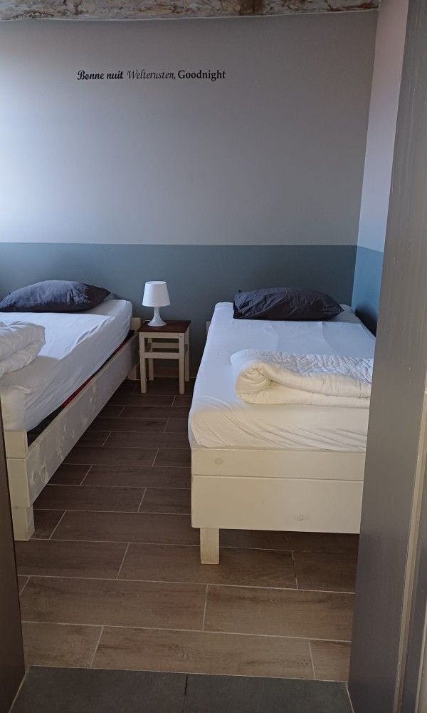 Slaapkamer met tweepersoonsbed en warme inrichting in Aan Maas & Grens vakantiehuis in Kinrooi, Limburg, Belgie.