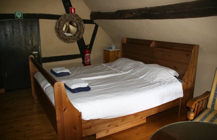 Sfeervolle slaapkamer in Huisje in Sint Pietersvoeren, een charmant vakantiehuis in het schilderachtige Limburg, Belgie.