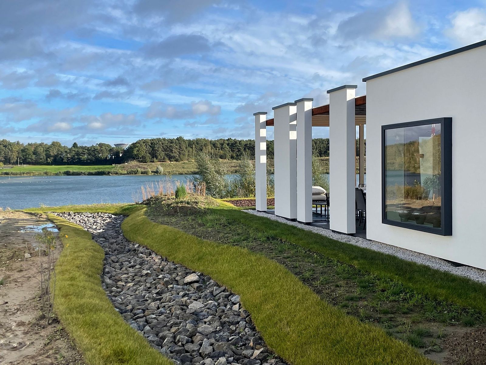 Vrijstaande woning in Zutendaal, Limburg biedt een prachtig uitzicht op het meer en de groene omgeving vanuit het moderne vakantiehuis.