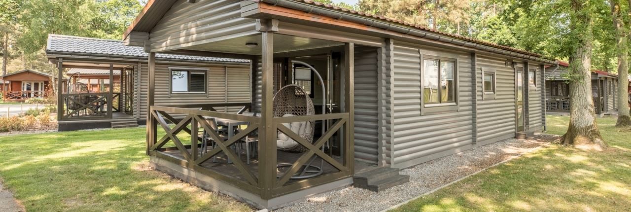 Veranda van Mooi Zutendaal 4-6-persoons chalet in Limburg, Belgie, met comfortabele zitplek en uitzicht op groene omgeving.