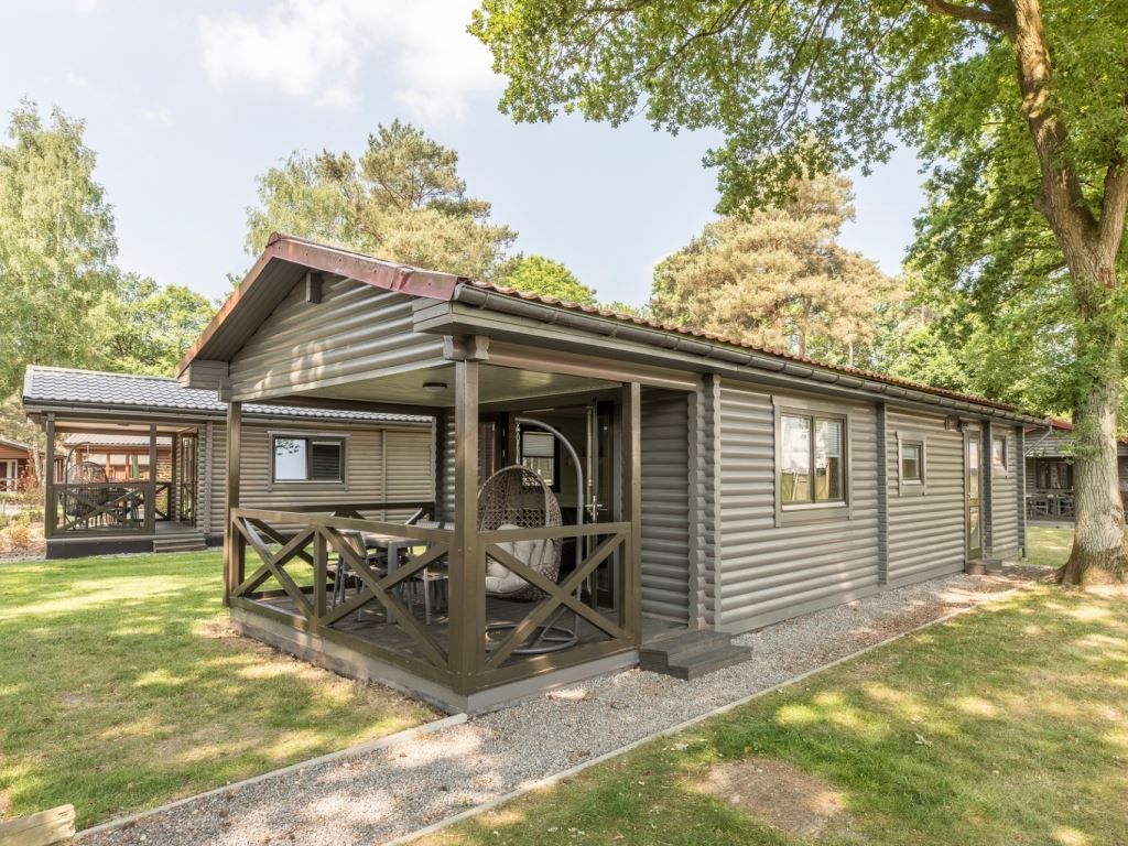Mooi Zutendaal chalet in Limburg, Belgie met veranda en groene omgeving, ideaal voor 4-6 personen.