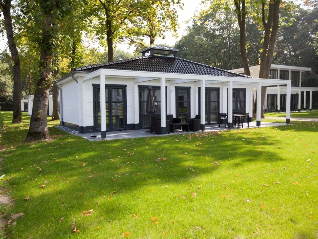 Mooi Zutendaal 4-persoons villa 4CE in Limburg, Belgie, omgeven door groene natuur en voorzien van een ruim terras voor ultiem buitenplezier.