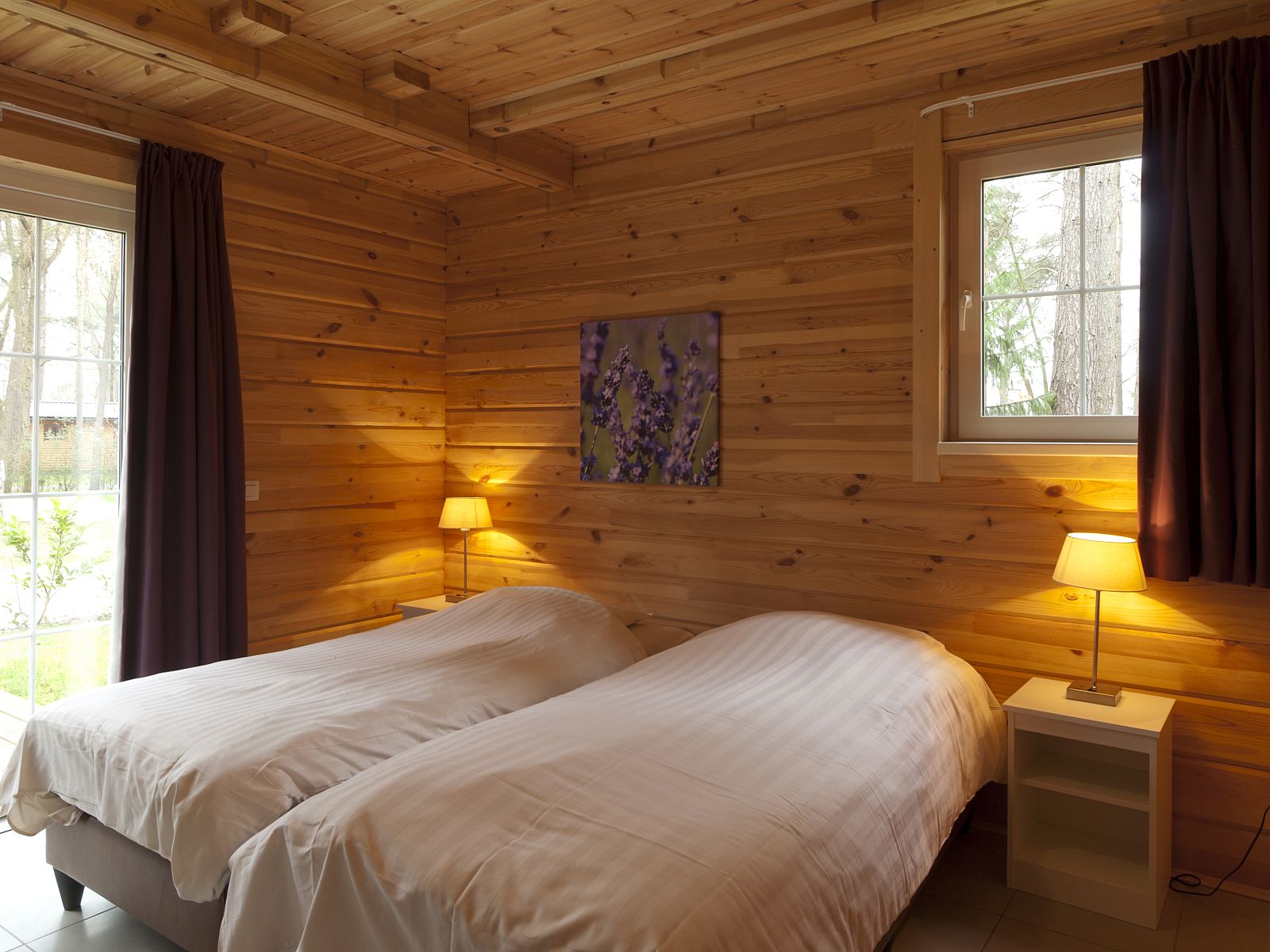 Gezellige slaapkamer in Mooi Zutendaal 4-persoons bungalow, Limburg. Houten interieur met comfortabele bedden en sfeervolle verlichting.