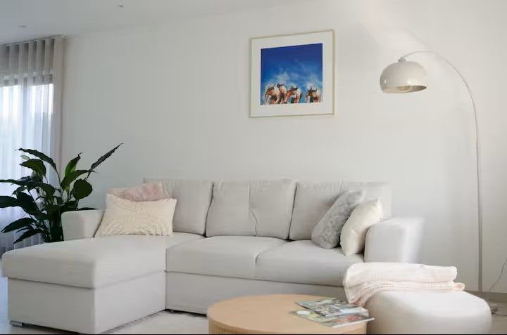 Stijlvolle woonkamer in vakantiehuis Ten Huyze Bucholt met comfortabele bank, gelegen in Bocholt, Limburg, Belgie.