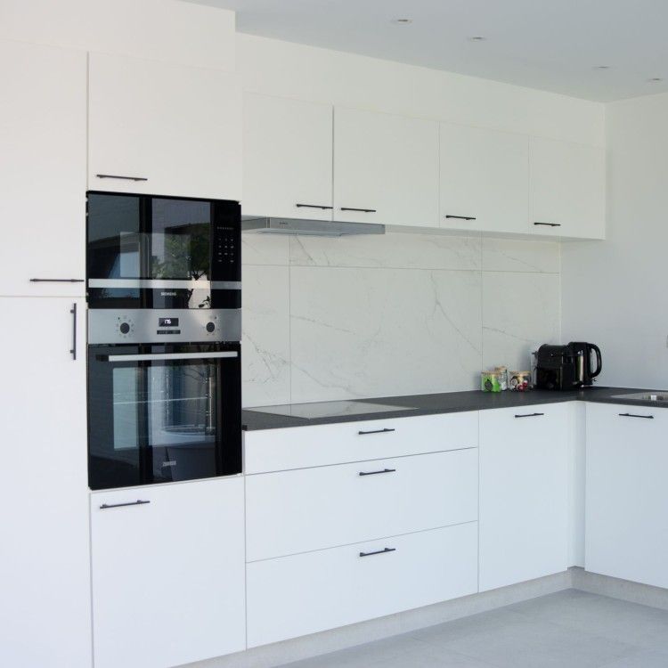 Moderne keuken in Ten Huyze Bucholt vakantiehuis in Bocholt, Limburg, Belgie met strakke witte kasten en luxe apparatuur.