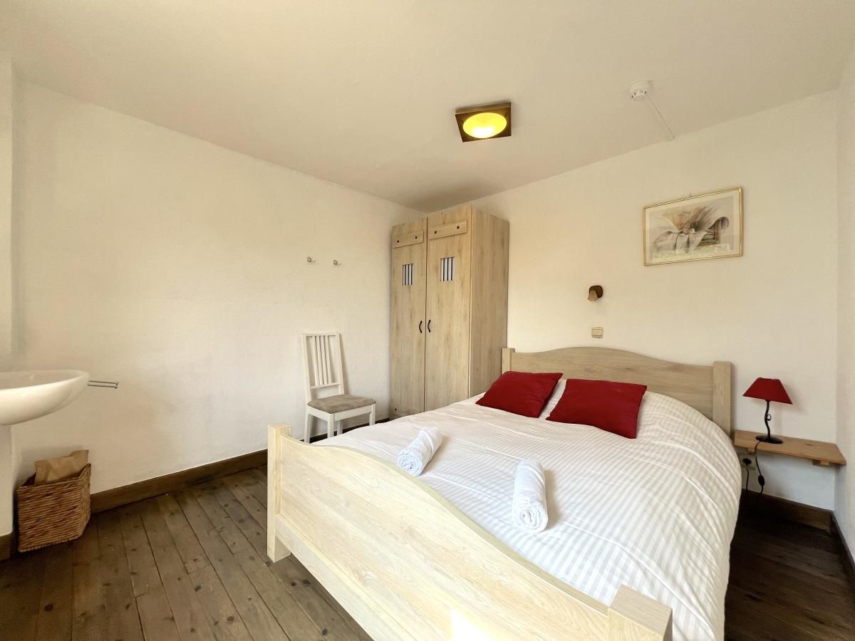 Komfortables Schlafzimmer im Ferienhaus Aux Hirondelles in Malmedy, Ardennen, mit Holzmoebeln.