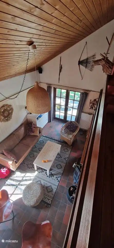 Gemuetliches Wohnzimmer des Chalets Pont du Waud in Waimes, Ardennen, Belgien, mit bequemer Sitzecke und Blick auf den Garten.