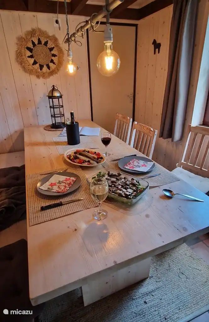 Gemuetlicher Essbereich im Chalet Pont du Waud in Waimes, Ardennen, Belgien, mit gedecktem Tisch und warmer Holzausstattung.