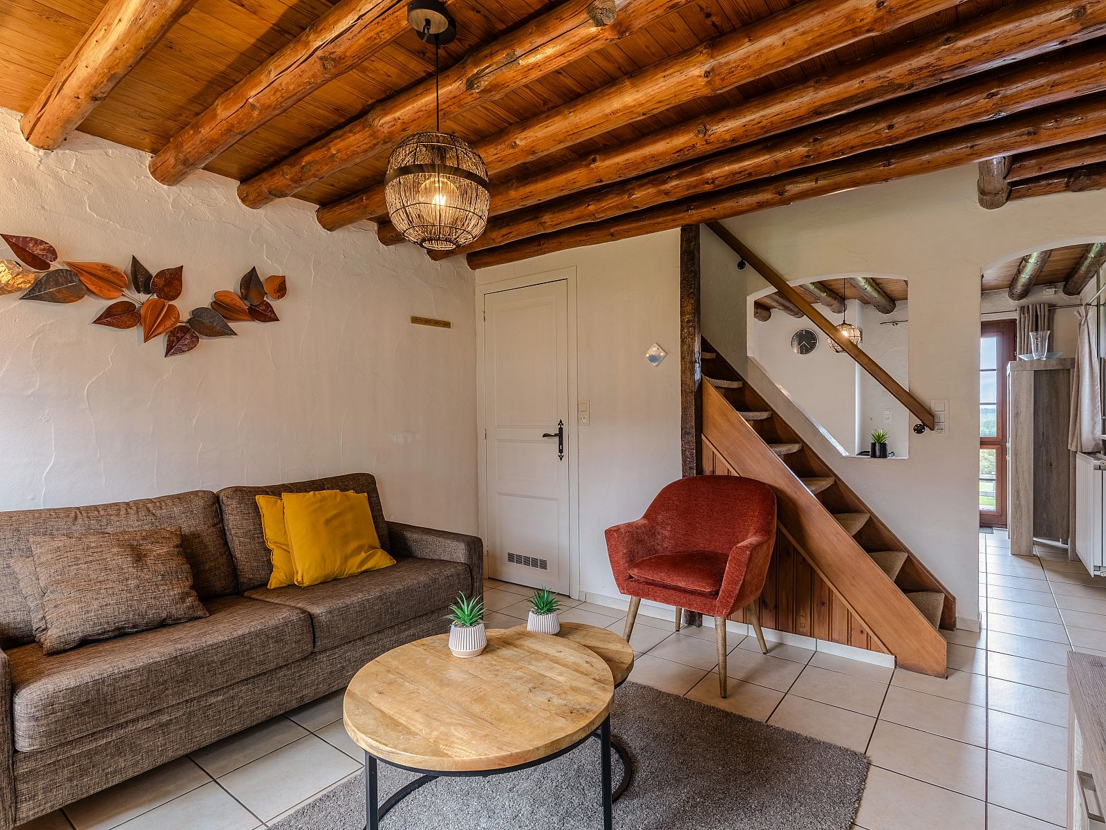Gezellige binnenruimte van Village les Gottales 4-persoons bungalow in Trois-Ponts, Ardennen. Houten balken en comfortabele zithoek.