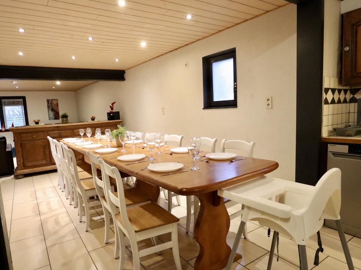 Gezellige eetkamer in vakantiehuis Annexe in Sourbrodt, Ardennen, Belgie, met lange houten tafel en comfortabele stoelen.