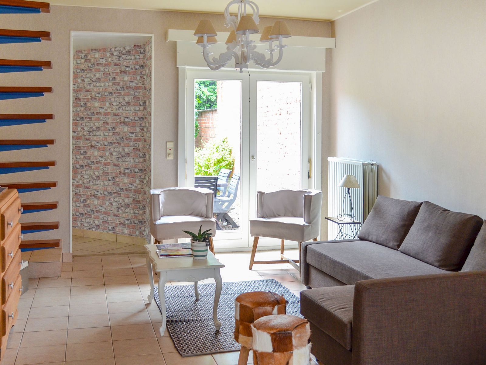 Gezellige woonkamer van Vakantiehuis Memories in Le Bizet, Henegouwen, Belgie, met comfortabele zitruimte en uitzicht op de tuin.