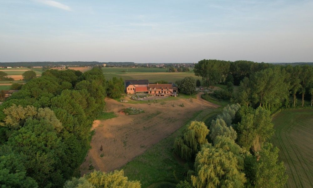Luchtfoto van vakantiehuis Favarge in Braine-Le-Comte, Henegouwen, Belgie, omgeven door uitgestrekte velden en groene natuur.