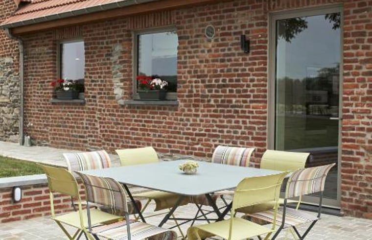 Buiten terras van Vakantiehuisje in Jollain, Henegouwen, Belgie met gezellige zitplek en bakstenen muren.