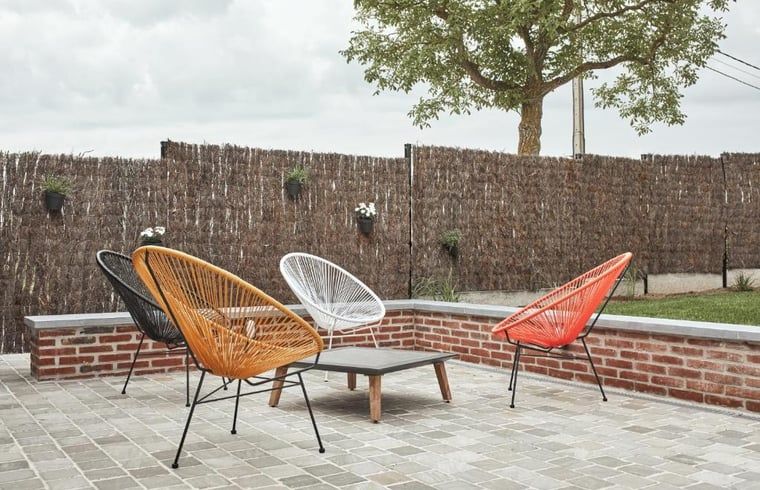 Modern terras met kleurrijke stoelen bij Vakantiehuisje in Jollain, Henegouwen, perfect voor buitenvermaak.