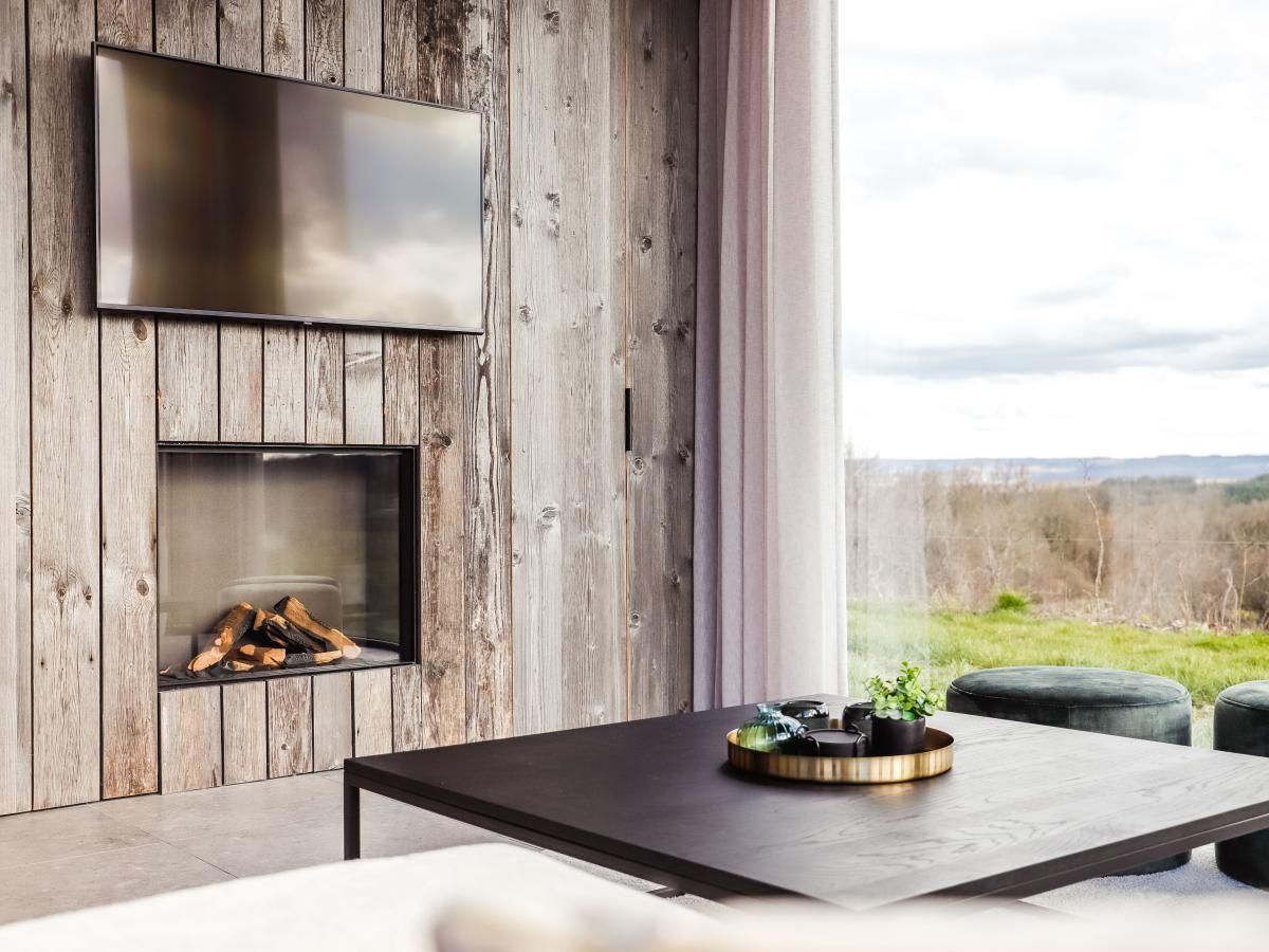 Gemuetliches Wohnzimmer des Ferienhauses La Ruree in Heure, Ardennen, mit moderner Einrichtung und Panoramablick auf die Natur.