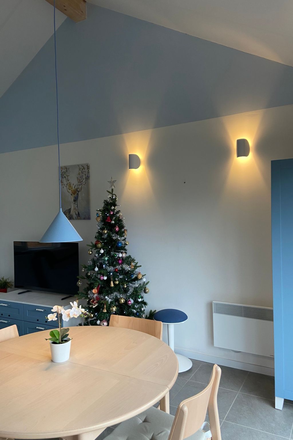 Gemuetliches Wohnzimmer im Ferienhaus Modernes Chalet in Heure, Ardennen, mit stimmungsvoller Weihnachtsdekoration und moderner Beleuchtung.