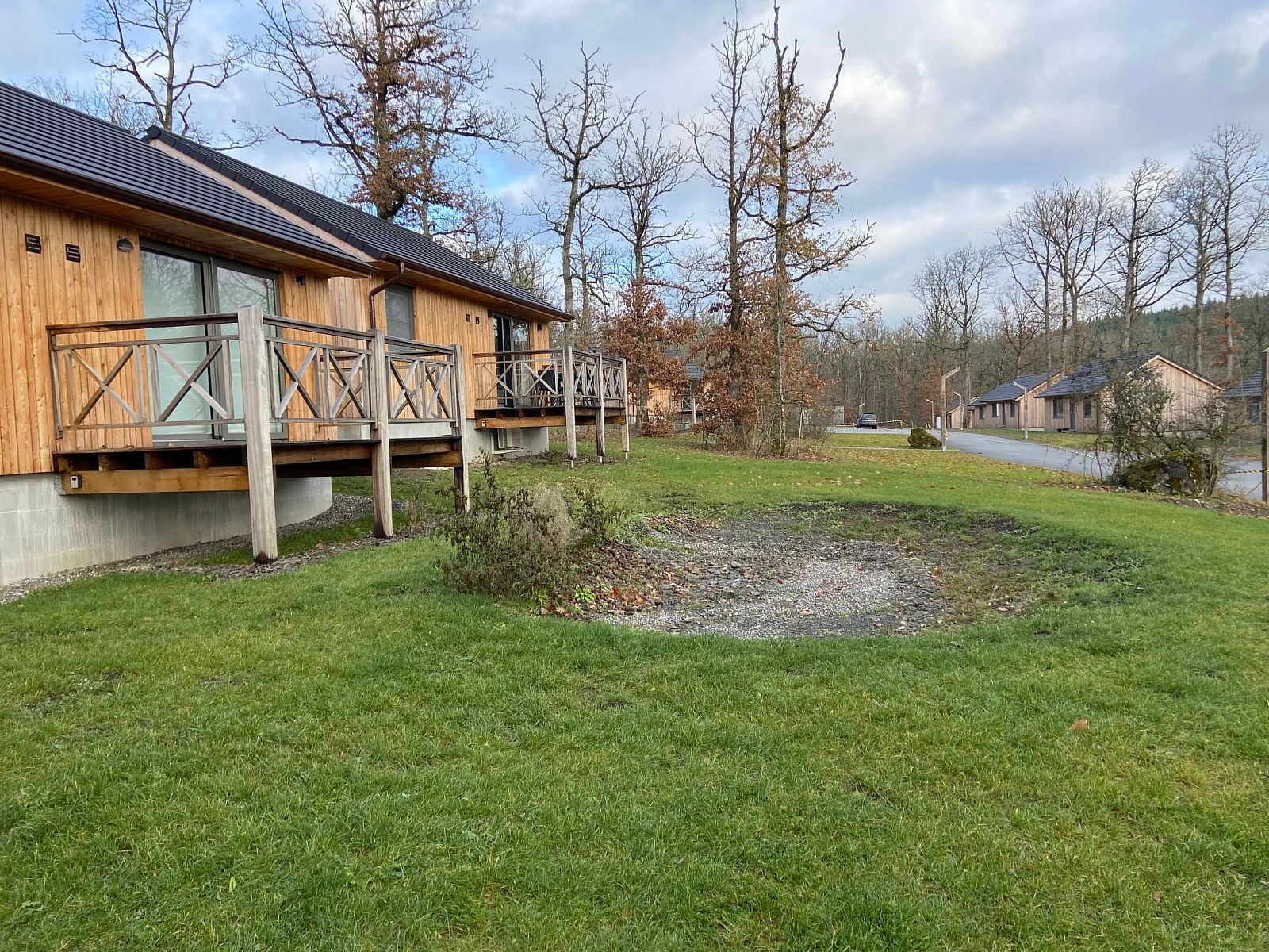 Ferienhaus Modernes Chalet fuer 4 Personen in Heure, Ardennen, Belgien, mit Holzveranda und Blick auf die waldreiche Umgebung.