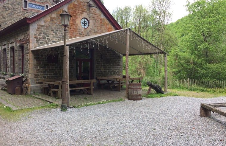 Gemuetliche Terrasse von Cottage in Purnode, Ferienhaus in den Ardennen, Belgien, umgeben von gruener Natur und rustikalem Charme.