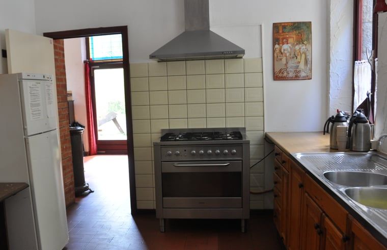 Geraeumige Kueche in Cottage in Purnode, Ferienhaus in den Ardennen, Belgien, mit modernen Geraeten und Blick auf den gemuetlichen Innenbereich.