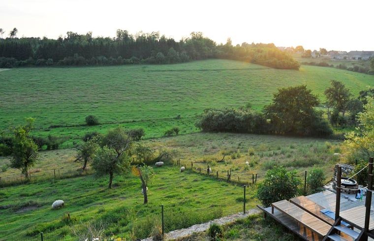 Geniessen Sie von der Terrasse des Ferienhauses in Aublain, das in den schoenen Ardennen in Belgien liegt, einen weiten Blick auf gruene Felder.