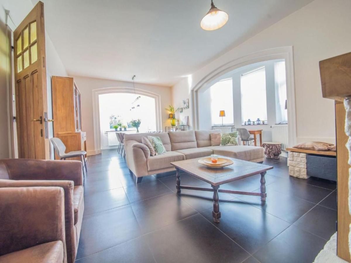 Stijlvolle woonkamer in Ma Dame Jeanne vakantiehuis, Durbuy, Ardennen, Belgie met comfortabele banken en veel natuurlijk licht.