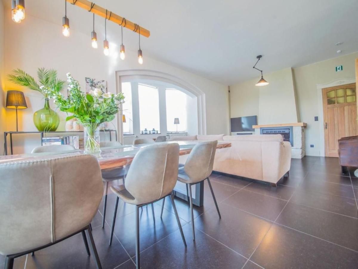 Gezellige woonkamer in Ma Dame Jeanne vakantiehuis, Durbuy, Ardennen. Comfortabele zithoek en eethoek met veel natuurlijk licht.