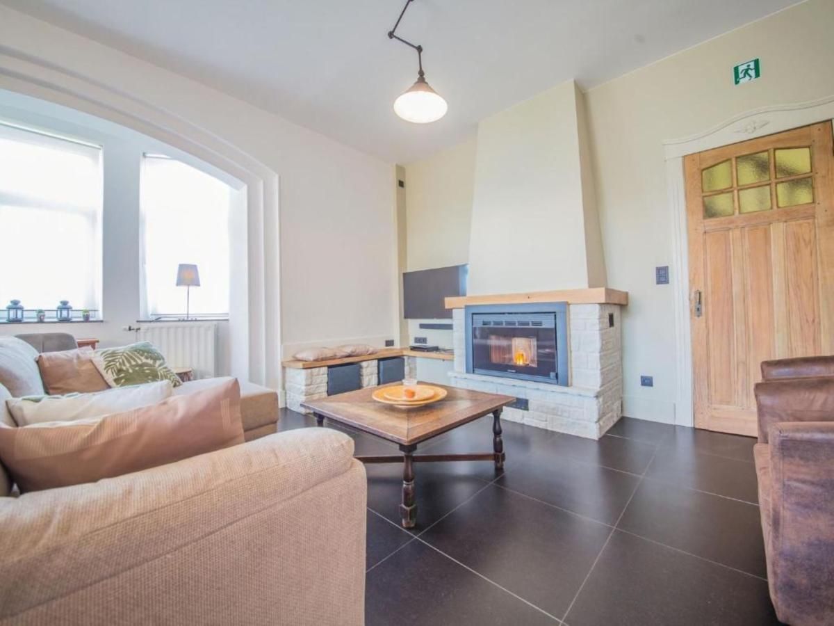 Gezellige woonkamer in Ma Dame Jeanne vakantiehuis, Durbuy, Ardennen, met open haard en comfortabele zithoek.