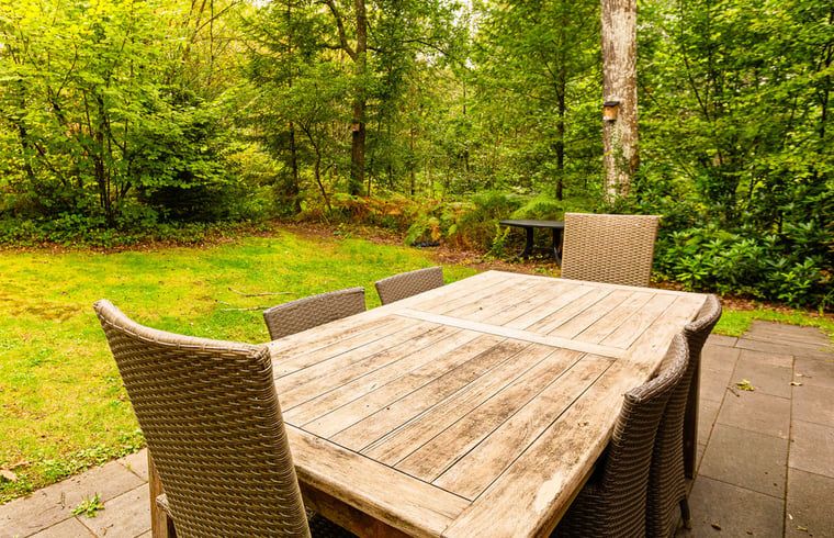 Gezellige woonkamer in Huisje in Izier, een vakantiehuis in de Ardennen, Luxemburg, Belgie, met warme bakstenen muren en comfortabele zitruimte.